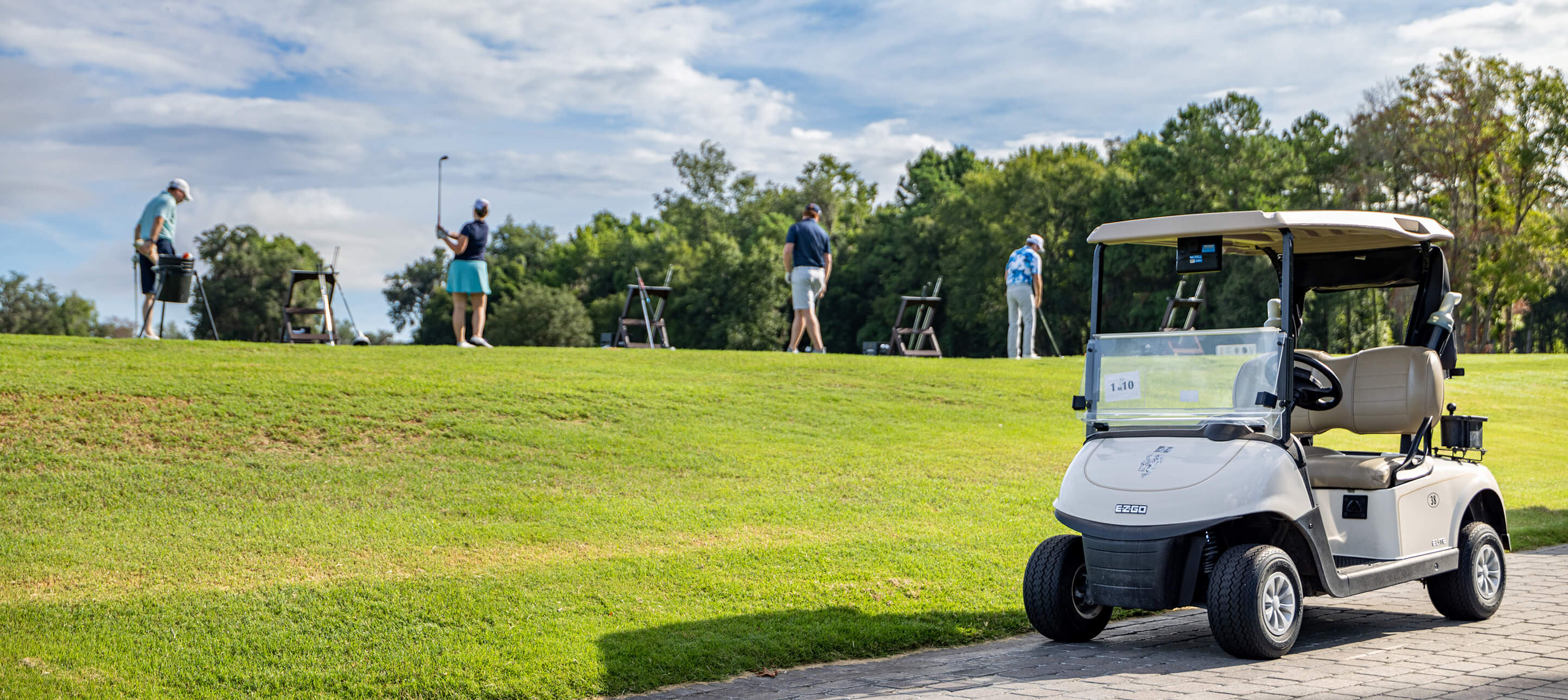 golfers and cart on course